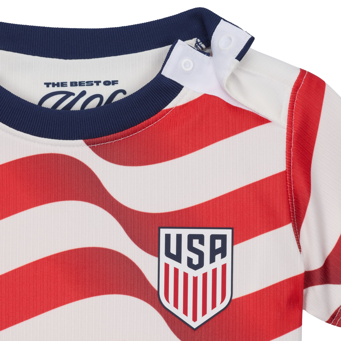 Close-up of a baby shirt with red and white wavy stripes, a navy blue collar, shoulder snaps, and the USA soccer team crest on the chest.
